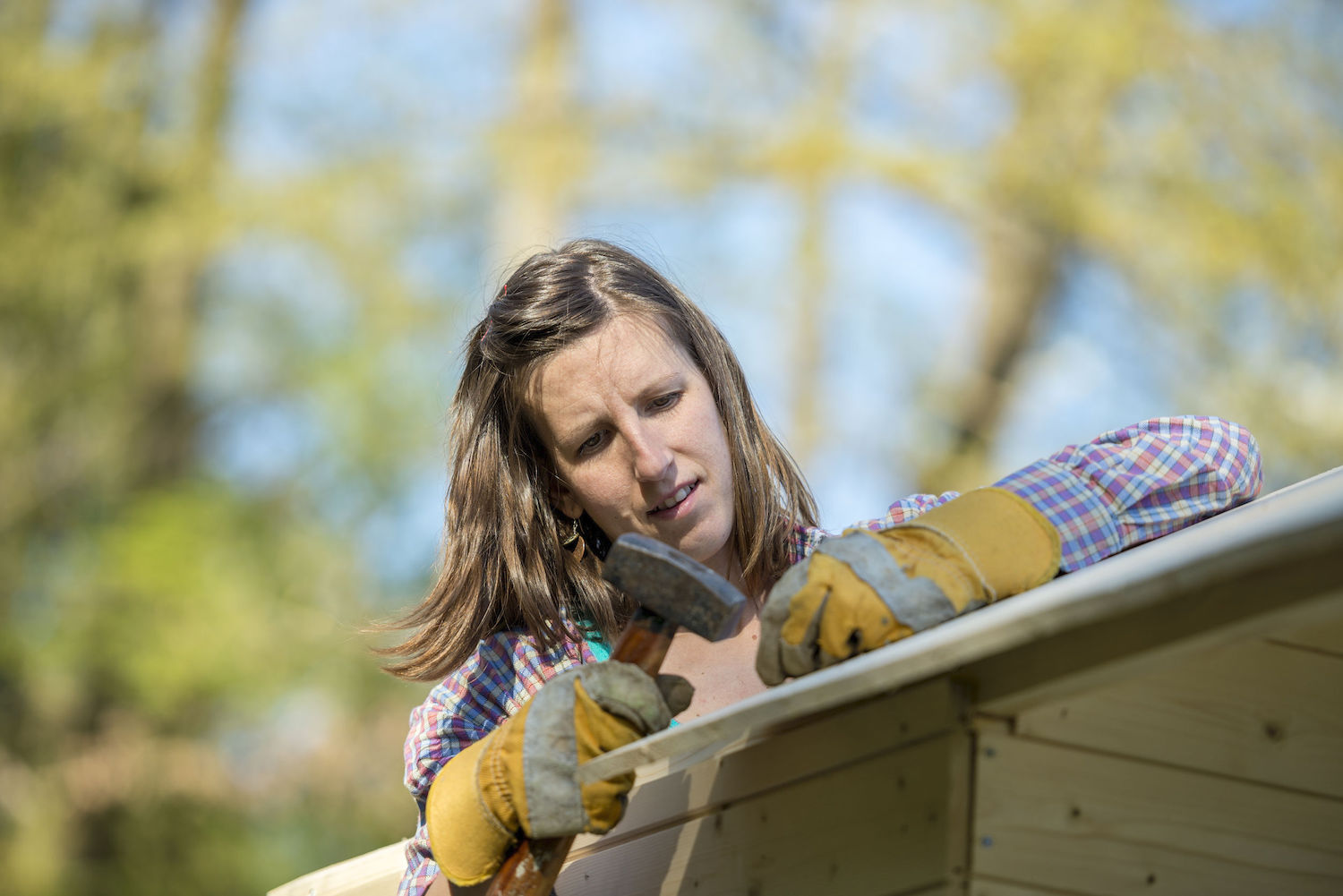 Young woman using a hammer to place a nail